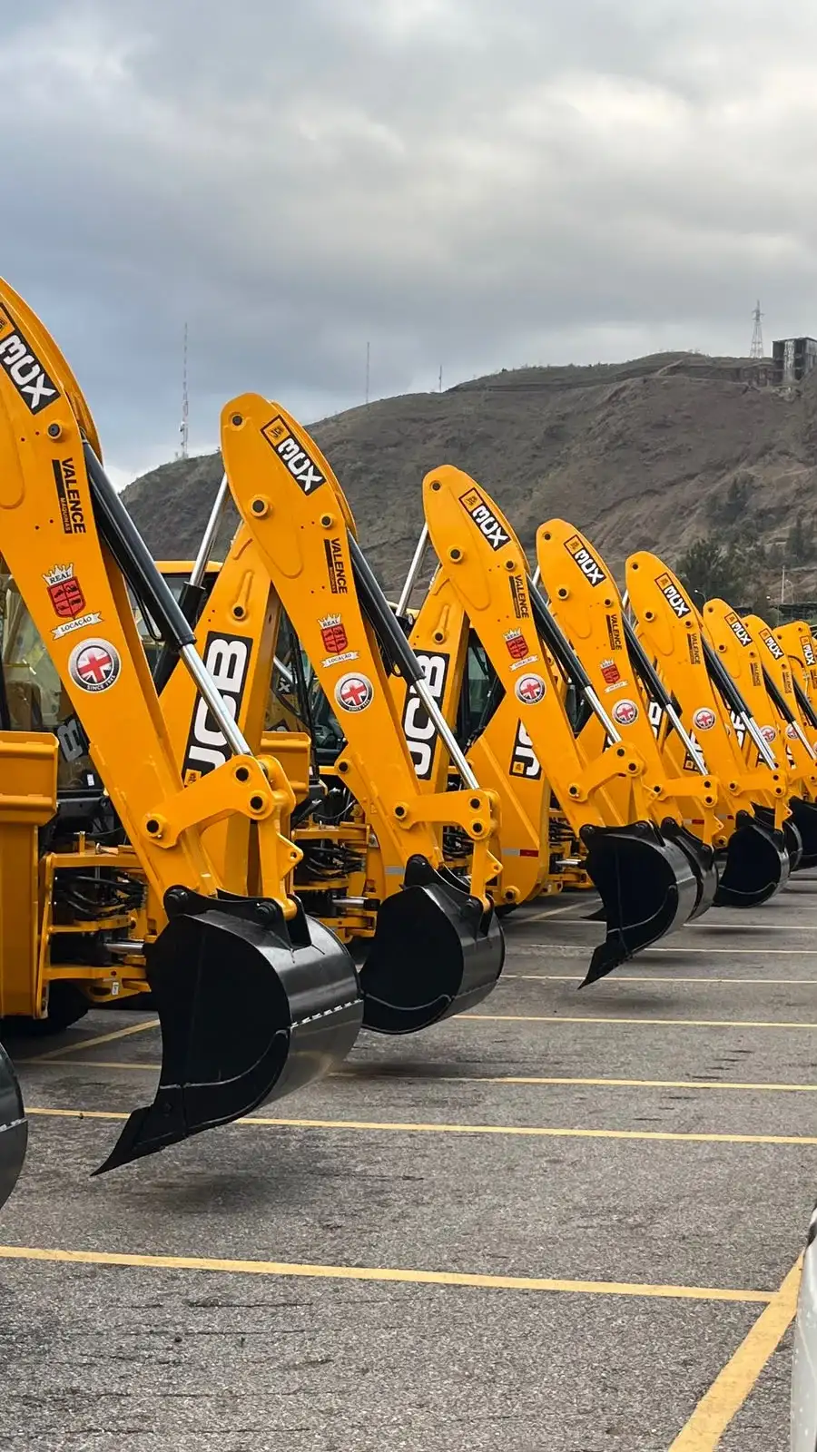 Fila de retroescavadeiras JCB 3CX da frota com os braços lado a lado